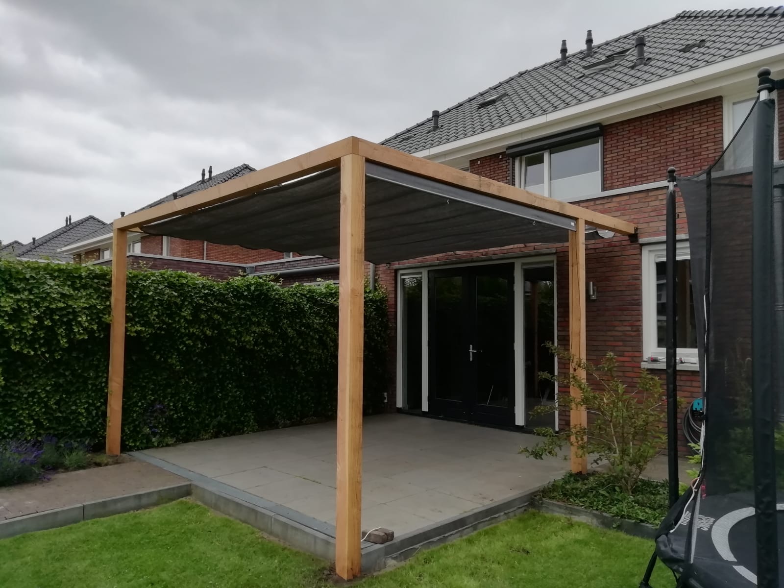 Aanleg Ongeschikt gerucht Plaatsen Douglas pergola met harmonica schaduwdoek in Eelderwolde,  Groningen - Hovenier Van Dijk Tuinen Groningen